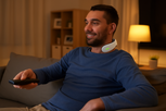 Man using RestEasy neck massager while watching TV at home